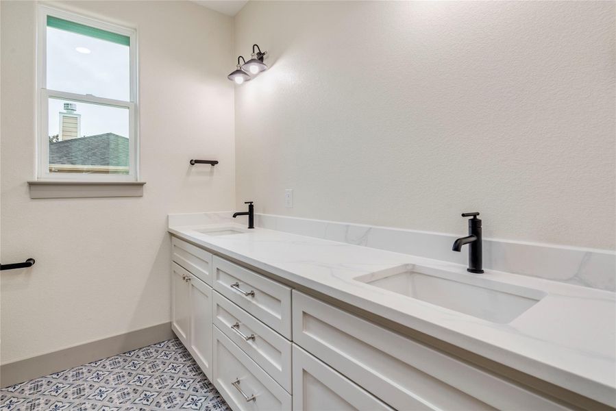 Bathroom featuring double vanity and baseboards