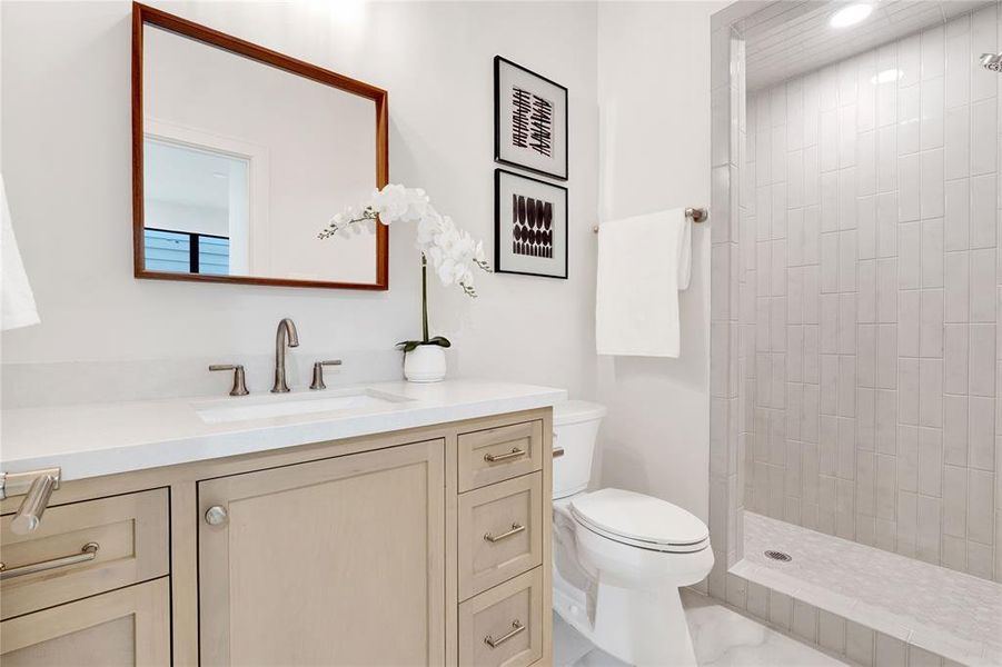 First floor full bathroom with custom made cabinets and a fully tiled standing shower.