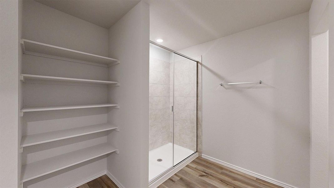 Bathroom featuring a stall shower, light wood finished floors, and recessed lighting