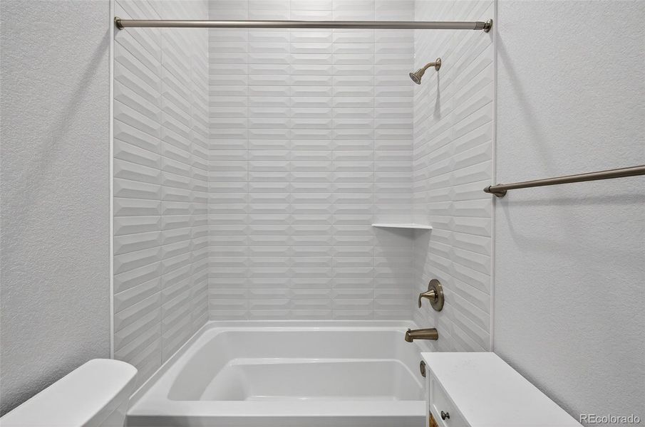 Bathroom (Tub & Shower View) – Secondary full bath featuring modern tile detailing, brushed-nickel fixtures, and a clean, contemporary design.