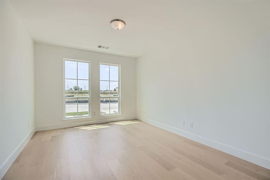 Unfurnished room featuring light wood-style flooring and baseboards