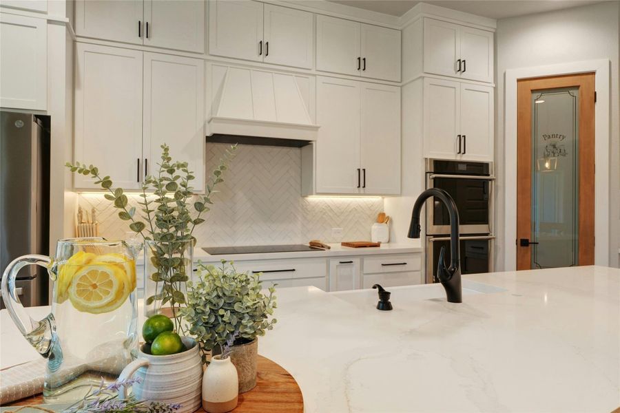 Well-appointed kitchen featuring a large island with an undermount sink and matte black faucet