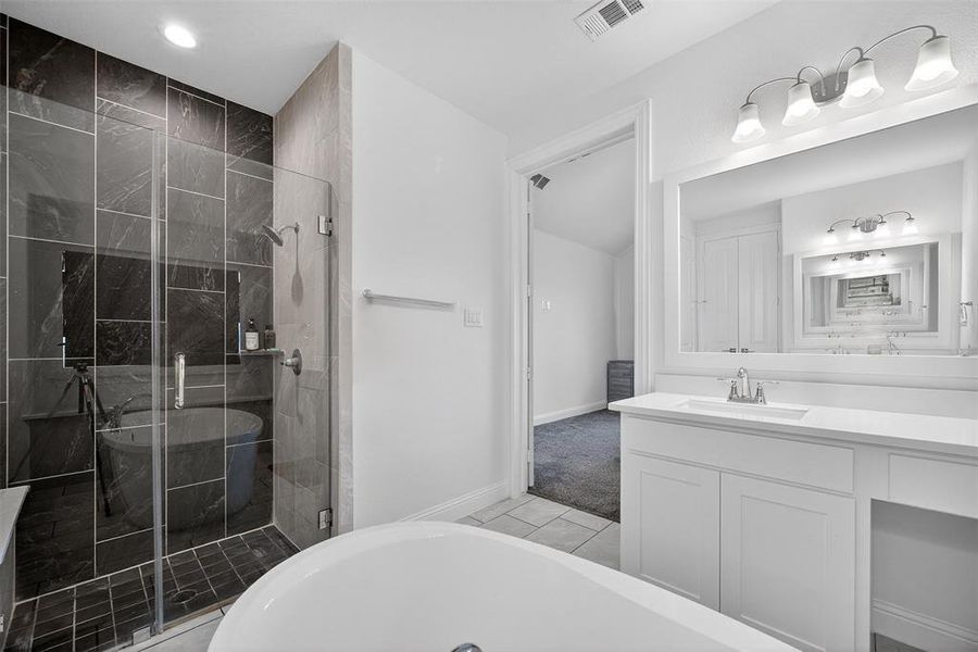 Bathroom with a soaking tub, vanity, and a stall shower Bathroom with a soaking tub, vanity, and a stall shower