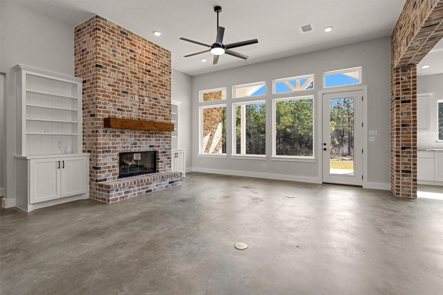 Large, open windows flood the space with natural light while offering peaceful views of the backyard and its mature trees. The seamless blend of indoor comfort and outdoor scenery creates a relaxing atmosphere, perfect for quiet evenings at home or gathering with family and friends.