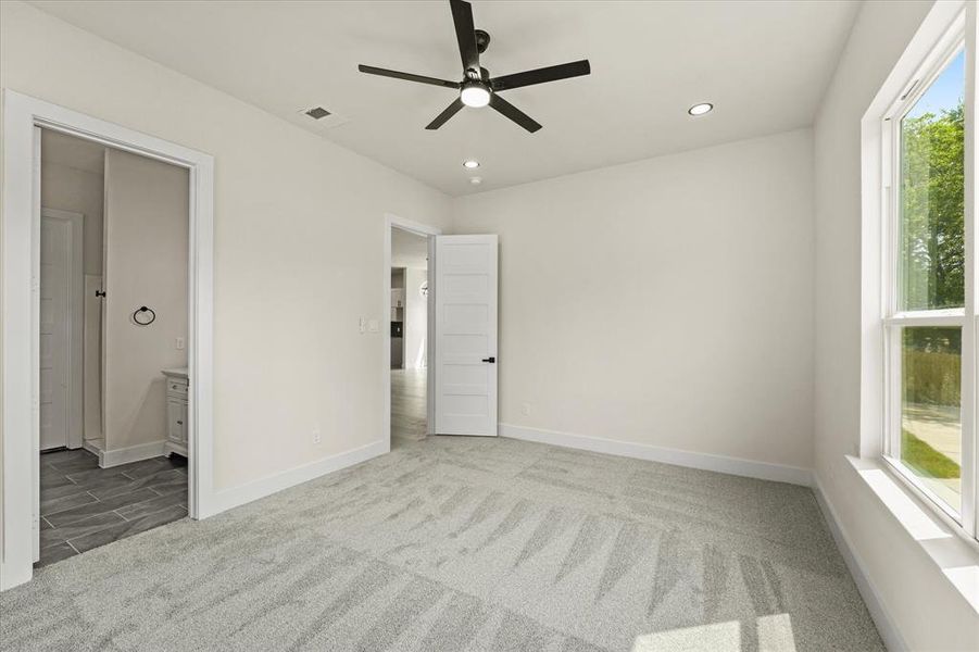 Unfurnished bedroom featuring light colored carpet, recessed lighting, ceiling fan, and ensuite bathroom Unfurnished bedroom featuring light colored carpet, recessed lighting, ceiling fan, and ensuite bathroom