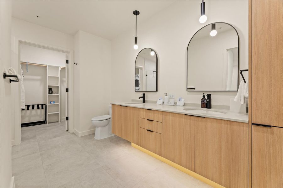 A spacious double vanity matches the wood-toned cabinetry in this modern washroom.