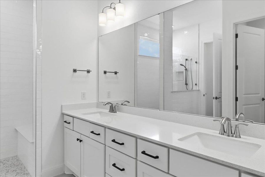 A well-appointed primary bathroom featuring a double vanity with ample counter space and a sleek walk-in shower. A well-appointed primary bathroom featuring a double vanity with ample counter space and a sleek walk-in shower.