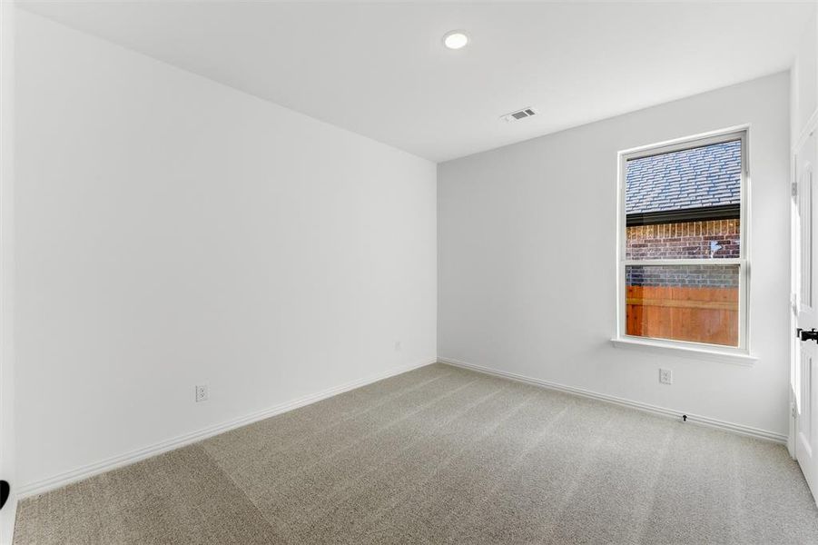 Empty room featuring light colored carpet and baseboards