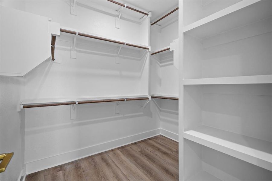 The property features a closet with built-in shelving, hanging rods, and wood-look flooring The property features a closet with built-in shelving, hanging rods, and wood-look flooring
