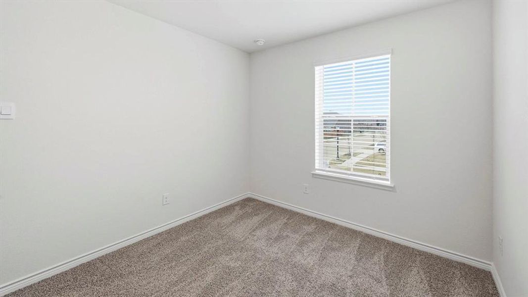 Carpeted room featuring a single window with blinds, white walls, and baseboard trim