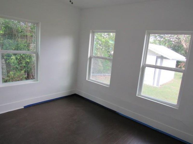 Spare room with baseboards and dark wood-type flooring Spare room with baseboards and dark wood-type flooring