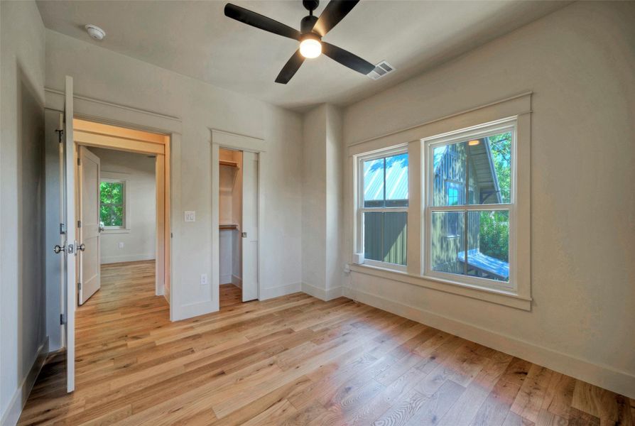 Bedroom 2 with warm hardwood floors and ample natural light.