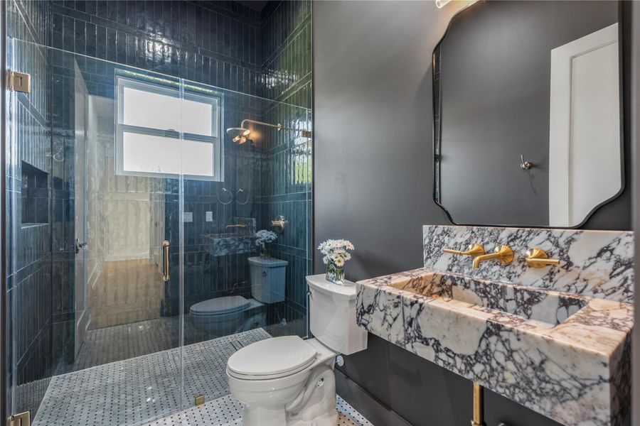 Powder bath featuring a walk-in shower and beautiful Calacatta Viola marble sink.