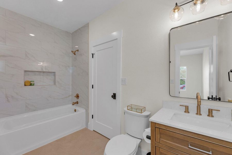 View of the bathtub with niche shelf.