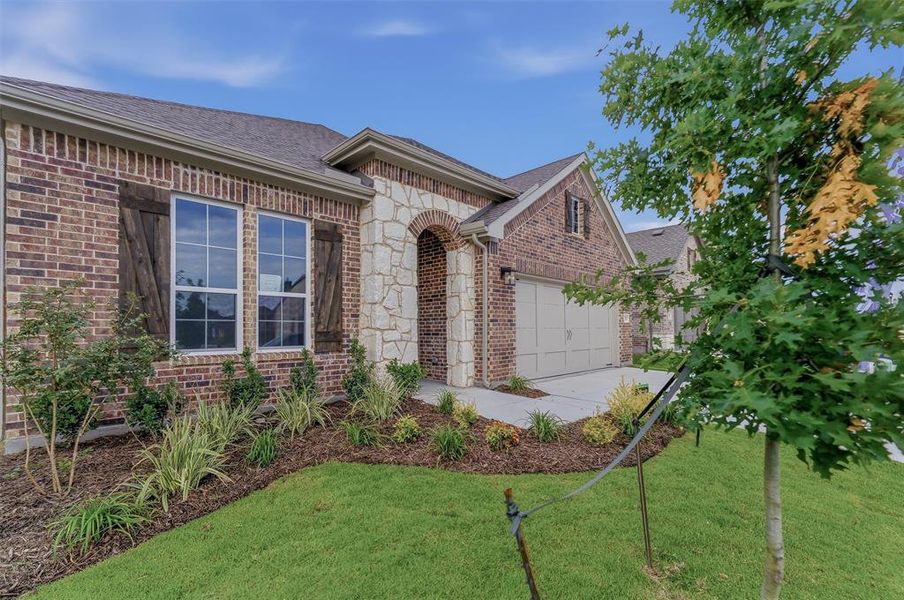 Brick facade with natural stone accents and an arched entry