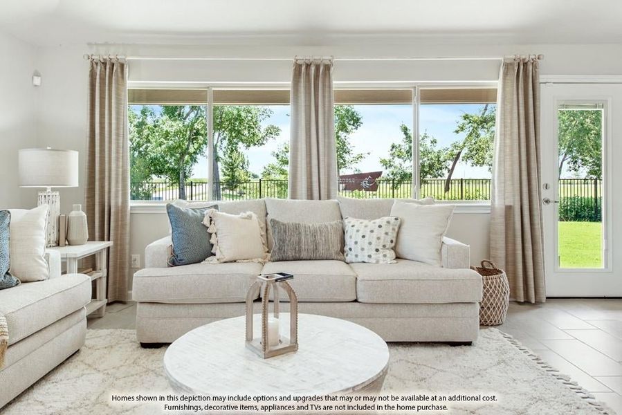 Bright living room with beige sofa, round coffee table, large windows, and patio door with outdoor views