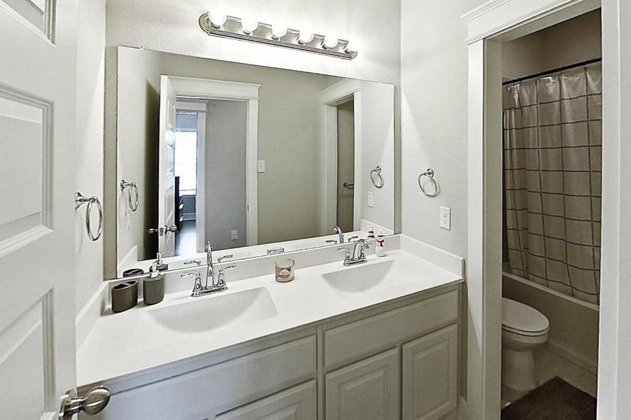 Full bathroom with shower / tub combo, vanity, and toilet