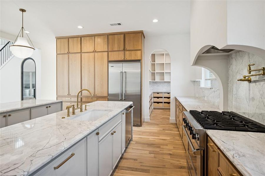 Double island and natural stone counter tops. Walking pantry.