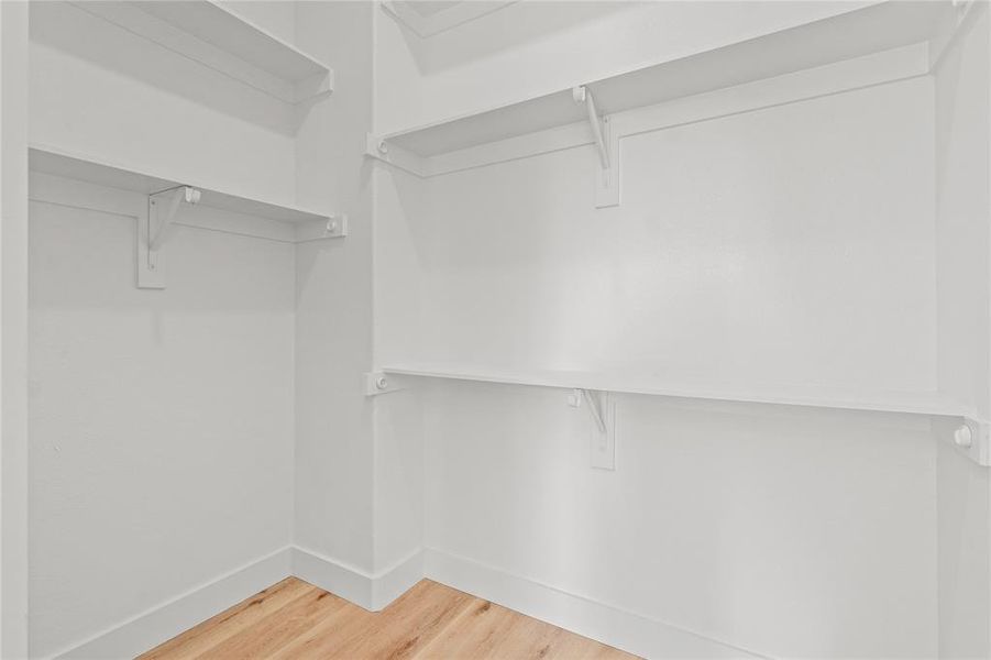 Spacious closet featuring light wood-type flooring Spacious closet featuring light wood-type flooring