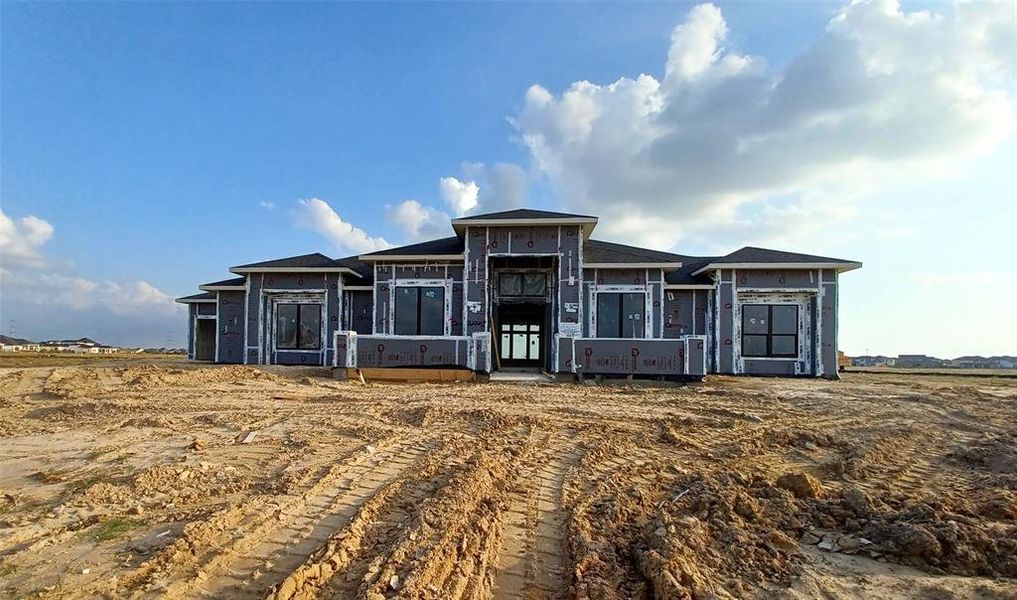 The modern elevation of this home boasts a sleek and contemporary design with stucco soon to come. It includes a four-car garage & is surrounded with windows, creating a bright and inviting atmosphere throughout the home.