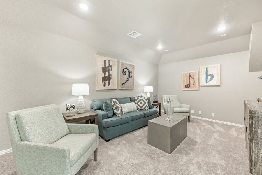 Living room with teal sofa, light green accent chair, gray carpet, and music-themed wall art Living room with teal sofa, light green accent chair, gray carpet, and music-themed wall art