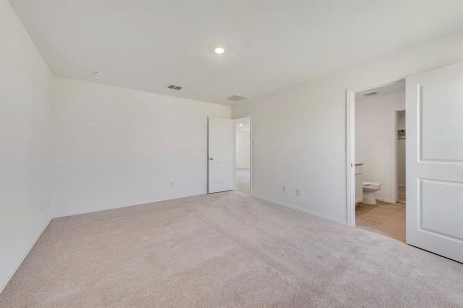 Unfurnished bedroom featuring light carpet and ensuite bath