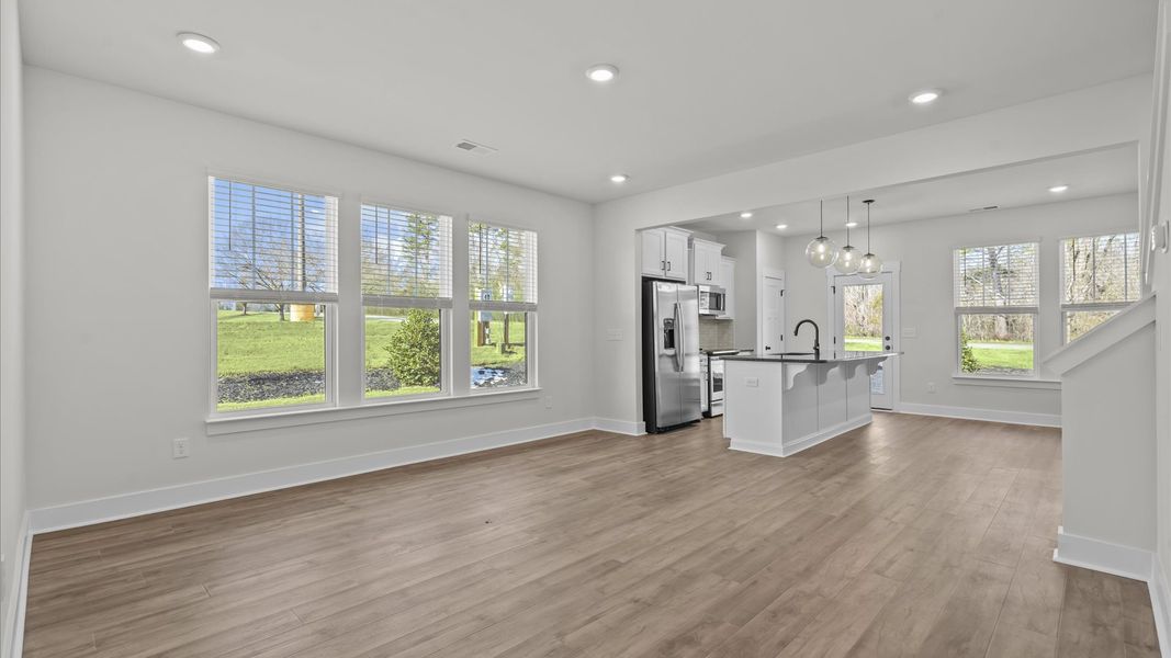 Elegant family room featuring hardwood flooring, large windows, and thoughtful architectural detail