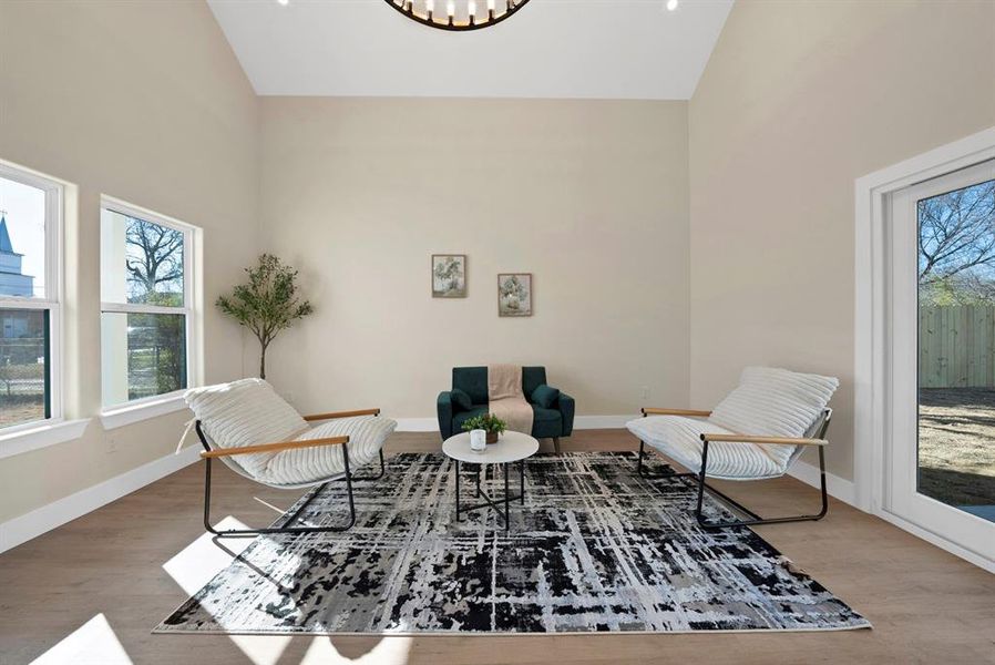 Sitting room featuring high vaulted ceiling and wood finished floors