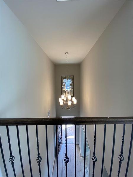 View from gameroom down to entry with tall cathedral ceiling, elegant Brushed Nickel chandelier, and rich hardwood floors(not stained yet.)