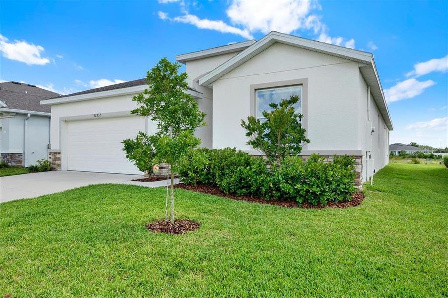 Front exterior of a new home in Woodcreek, Wesley Chapel, FL, highlighting curb appeal (Image 27).