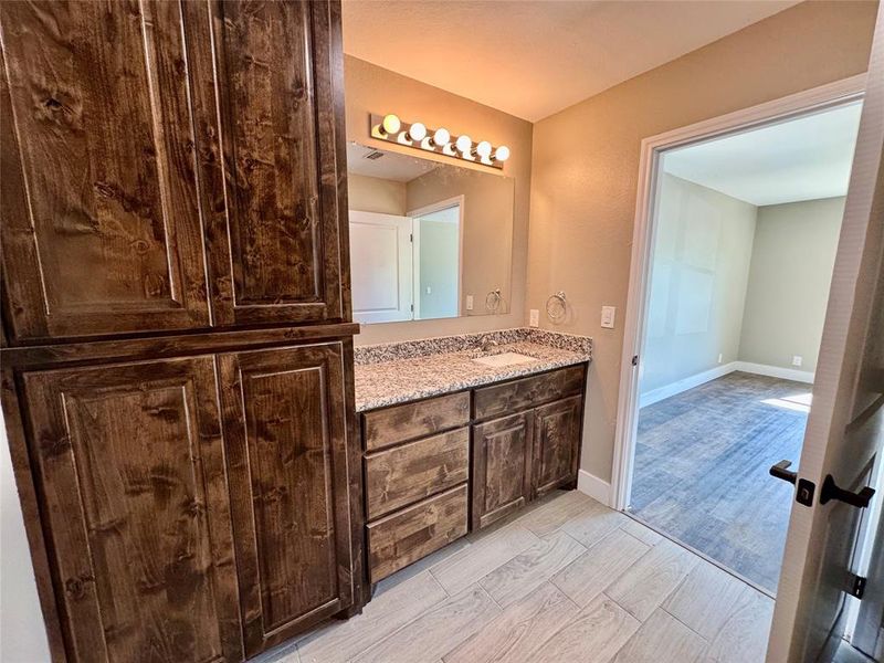 Bathroom with double vanity and wood finish floors