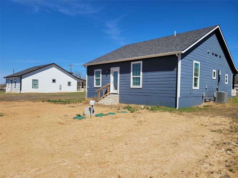 Back of house featuring entry steps and a shingled roof