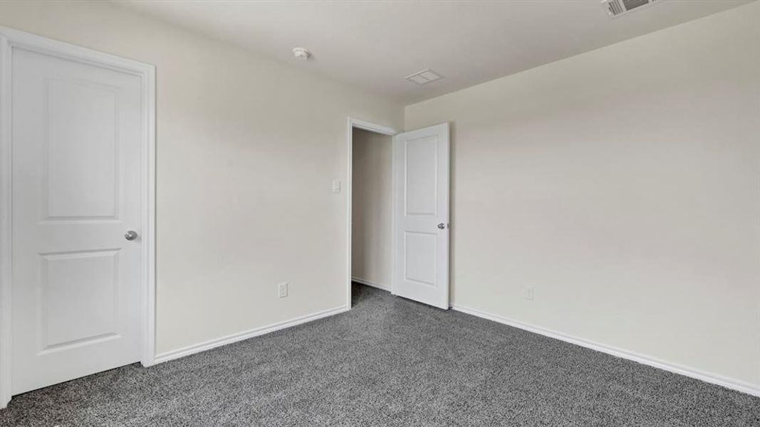 Neutral wall tones complement the dark gray carpeting