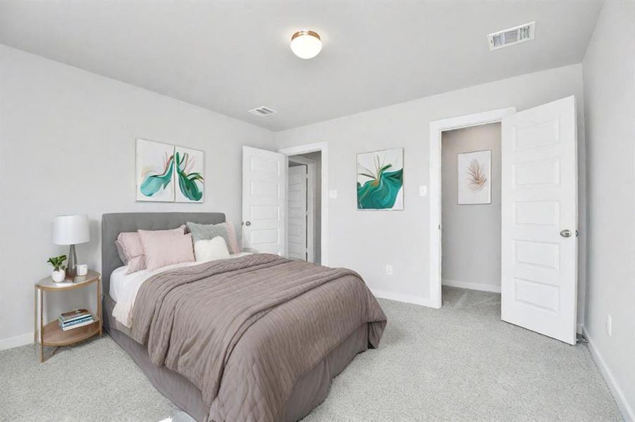 Generously sized secondary bedrooms featuring spacious closets, soft and inviting carpeting underfoot, large windows allowing plenty of natural light. Sample photo of completed home with similar floor plan. As-built interior colors and selections may vary.