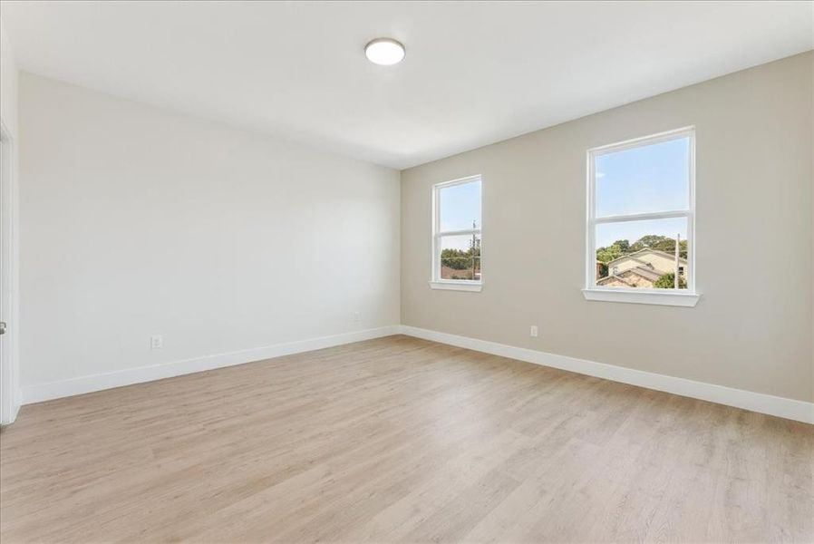 Empty room with light wood-type flooring and baseboards