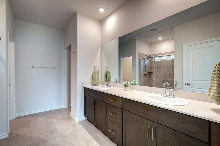 Bathroom with tile patterned flooring, vanity, and an enclosed shower