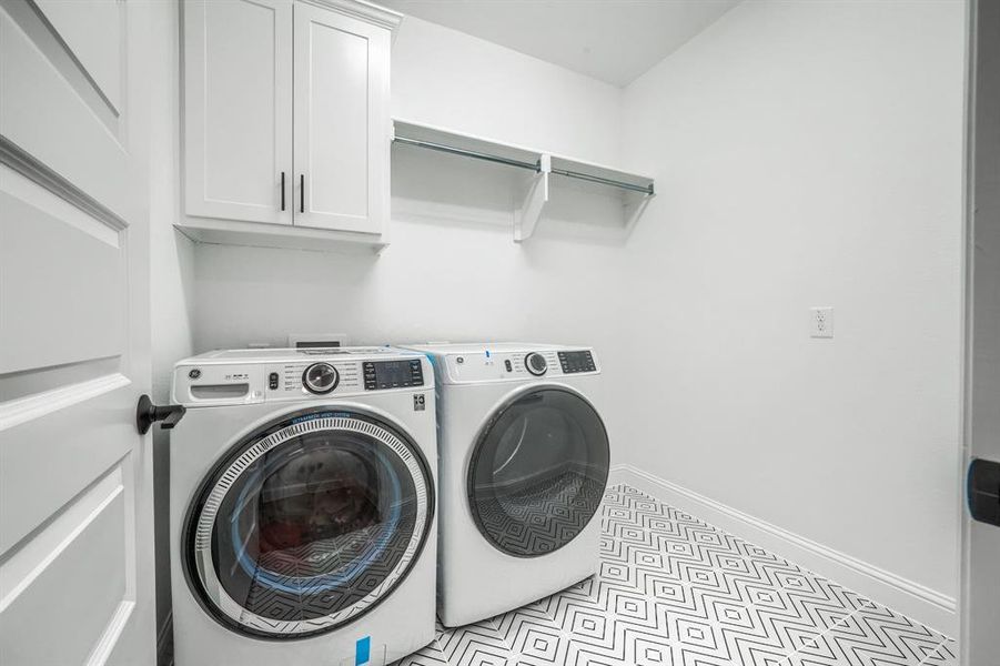 Laundry room with baseboards, cabinet space, and separate washer and dryer