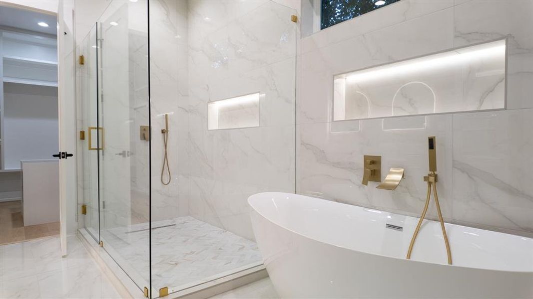 Full bath featuring a soaking tub, a marble finish shower, marble tiled flooring, and tile walls