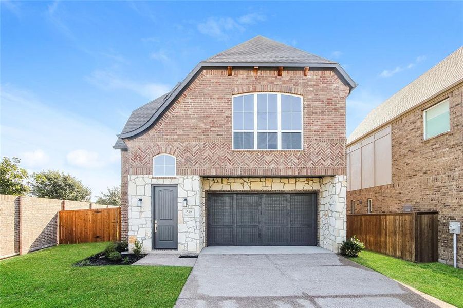 View of front property featuring a garage and a front lawn