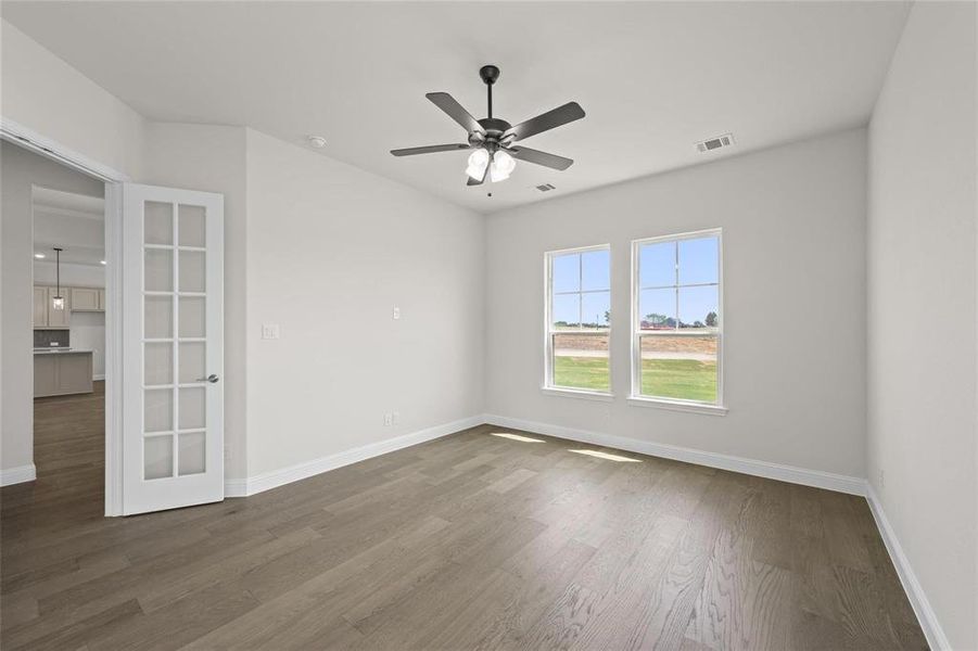 Unfurnished room featuring ceiling fan and hardwood / wood-style floors