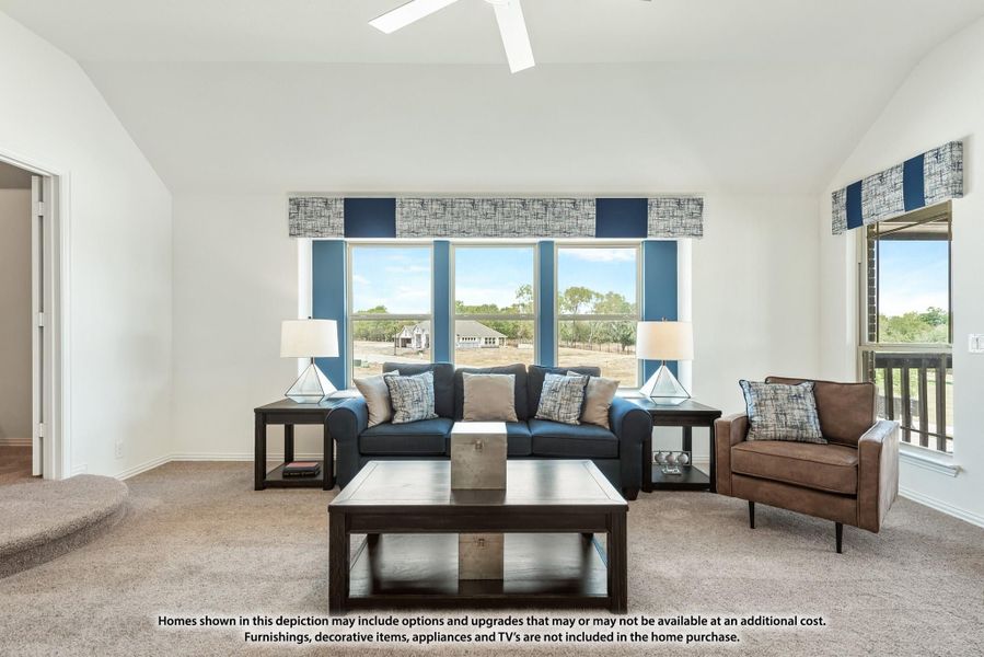 Living room with vaulted ceiling, blue sofa, ceiling fan, and large windows with outdoor views Living room with vaulted ceiling, blue sofa, ceiling fan, and large windows with outdoor views