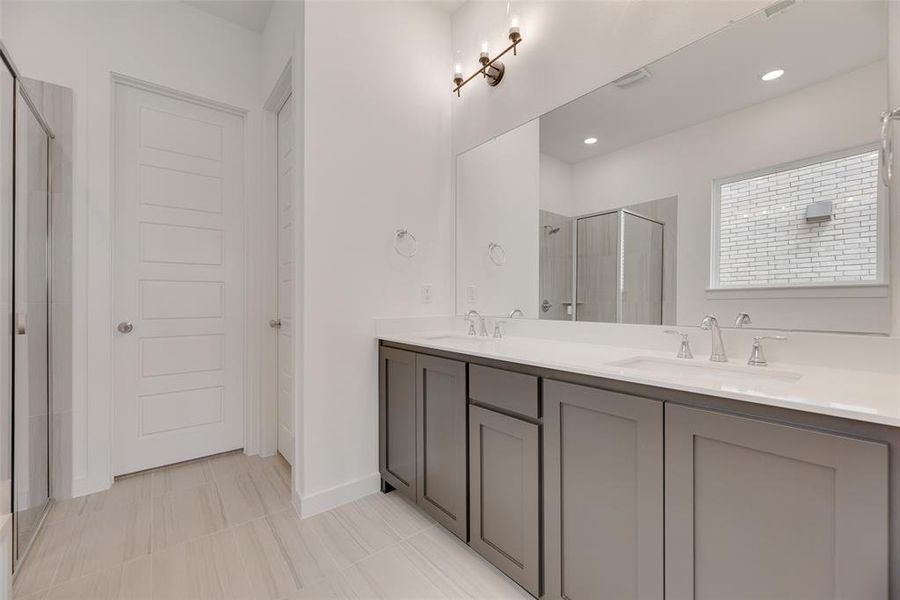 Bathroom with a stall shower, double vanity, and light tile patterned floors Bathroom with a stall shower, double vanity, and light tile patterned floors