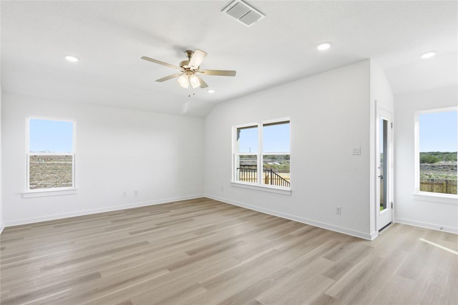 Unfurnished room with plenty of natural light, light wood finished floors, lofted ceiling, a ceiling fan, and recessed lighting