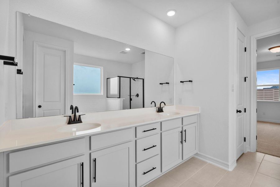 Modern primary bath featuring the AW Foundry Collection with bright cabinetry, light countertops with matte black fixtures and an oversized vanity. Modern primary bath featuring the AW Foundry Collection with bright cabinetry, light countertops with matte black fixtures and an oversized vanity.