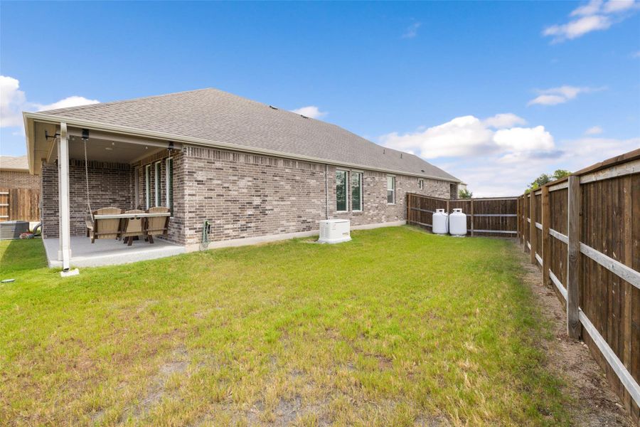 Back of house featuring a fenced backyard, a shingled roof, a patio, and brick siding Back of house featuring a fenced backyard, a shingled roof, a patio, and brick siding