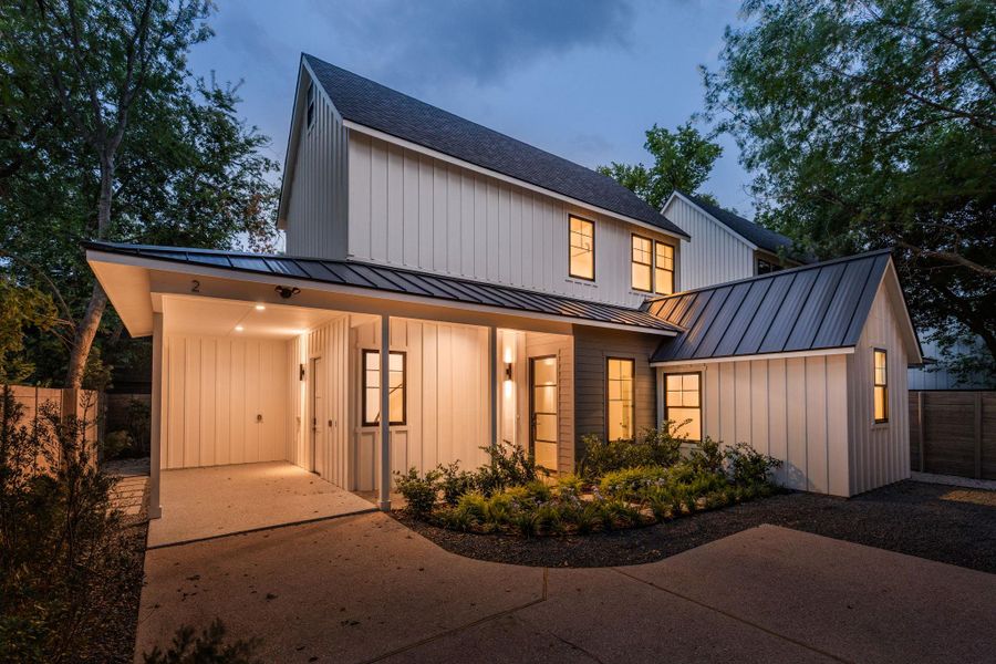 Modern farmhouse style home with board and batten siding, a metal roof, concrete driveway, and a standing seam roof Modern farmhouse style home with board and batten siding, a metal roof, concrete driveway, and a standing seam roof
