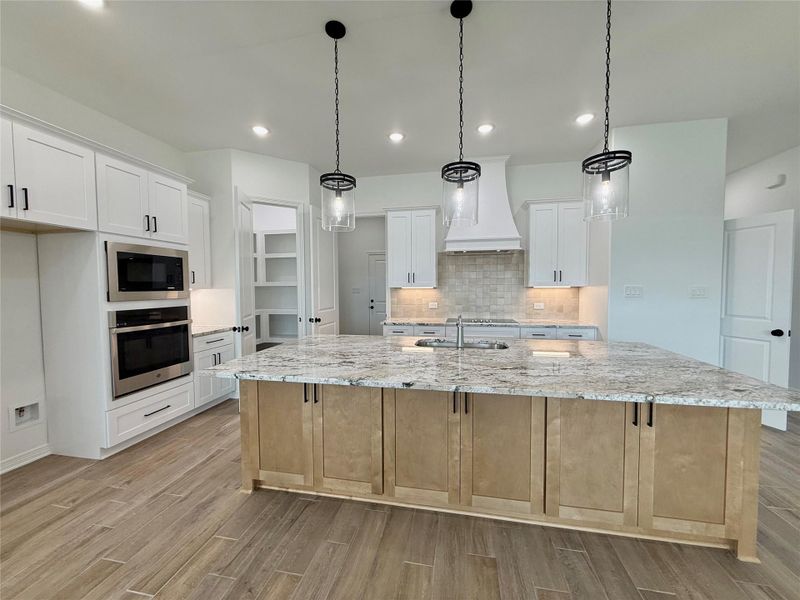 Expansive kitchen island featuring a light-toned countertop and contrasting base cabinetry