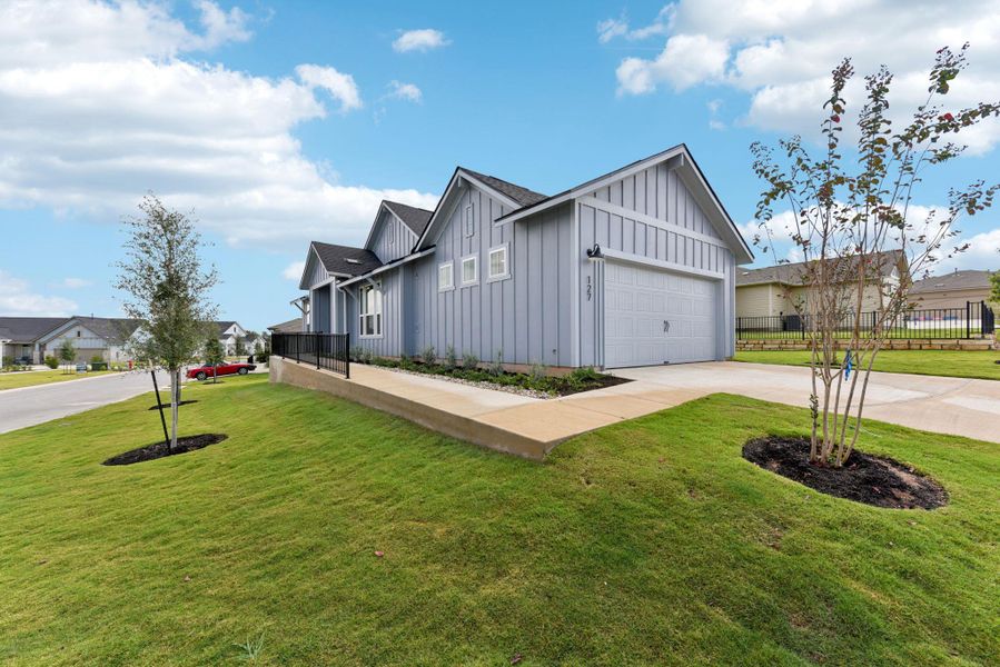 View of home's exterior featuring board and batten siding, driveway, a garage, a shingled roof, and a residential view