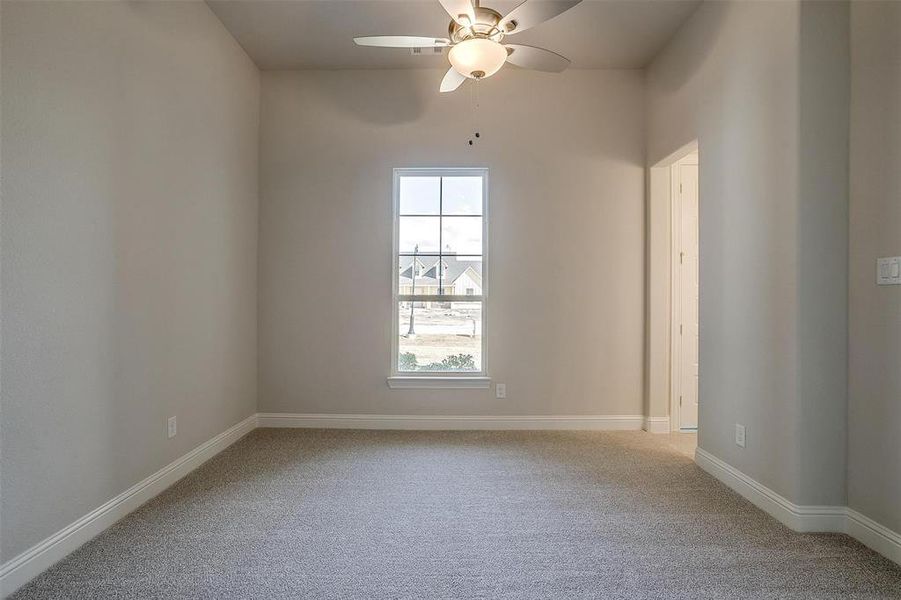 Carpeted empty room with ceiling fan