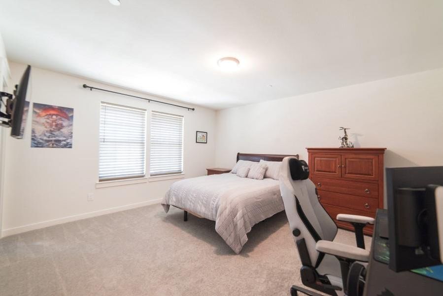 Bedroom featuring light colored carpet and baseboards